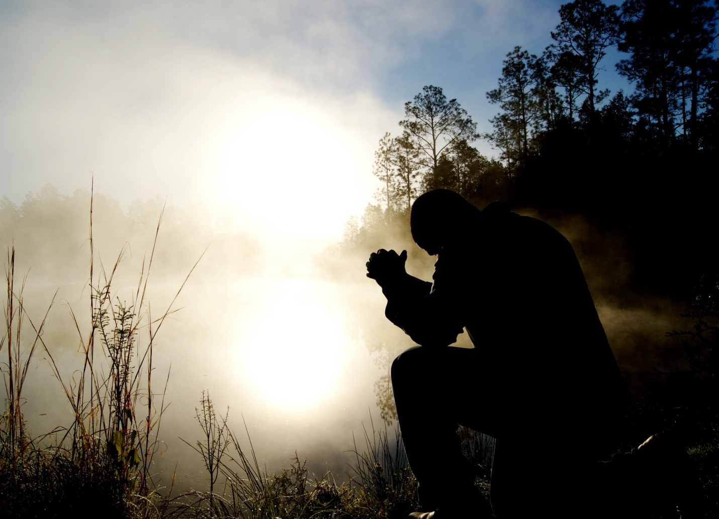 A man praying by the lake