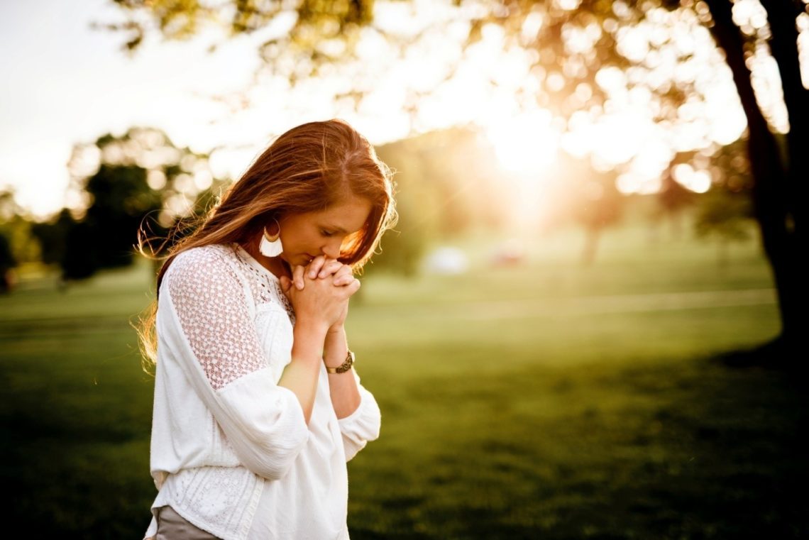 A woman praying in a park